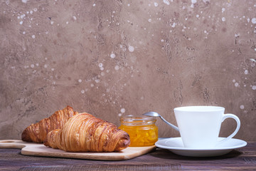 Two tasty classical croissant and coffee cappuccino on table