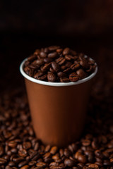 Take away black coffee cup with roasted coffee beans. Space for application logo