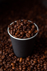Take away black coffee cup with roasted coffee beans. Space for application logo