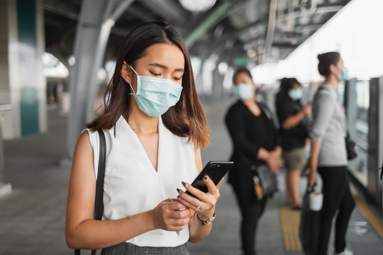 Coronavirus(Covid-19) concept, Asian woman wearing protective face mask to protect infection from coronavirus covid-19 standing at sky train and crowd people