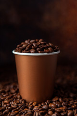 Take away black coffee cup with roasted coffee beans. Space for application logo