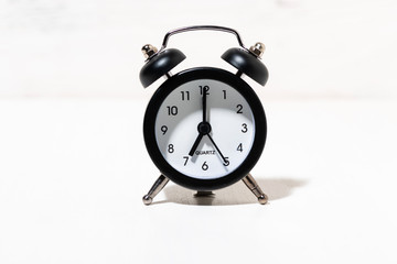 black alarm clock on white background, conceptual photo
