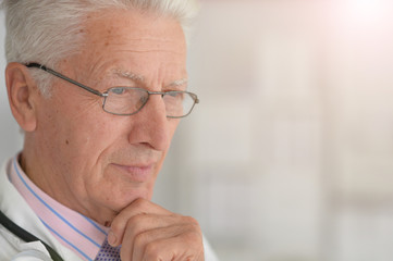 Close up portrait of sad senior male doctor posing