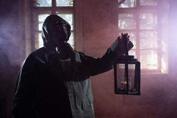 Dramatic portrait of a woman wearing a gas mask in a ruined building.