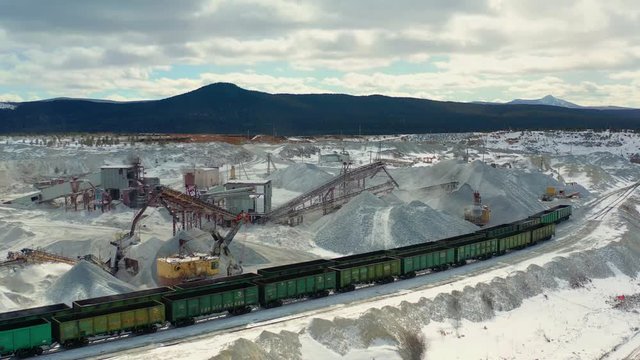 Crushed stone quarry, crawler excavator loads crushed stone in railway cars