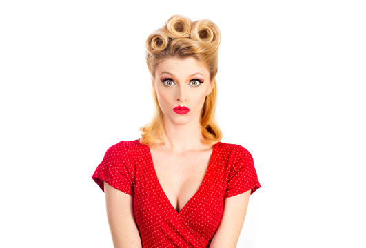 Portrait of beautiful young surprised woman, dressed in red pin-up dress. Caucasian blond model posing in retro fashion concept. Thinking, daydreaming. Serious young woman.