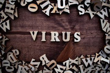 The word "Virus" spelt out with wooden letters on the wooden background. Coronavirus China COVID-19 concept.