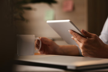 Close-up of businesswoman surfing the net on touchpad on coffee break in the office.