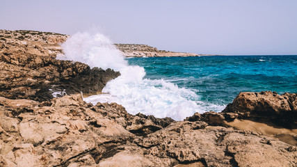 Fototapeta na wymiar Very waves breaking against stones