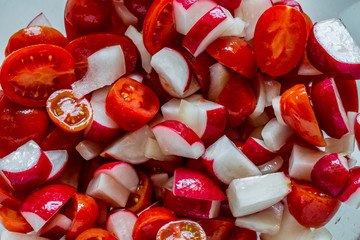 Fresh vegetable summer salad: tomatoes and radishes. Food photography. Close up