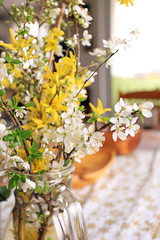 Vase with spring flowers cherry blossoms and Forsythia.