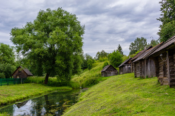 Fototapeta na wymiar Old village by the river. Old wooden houses.