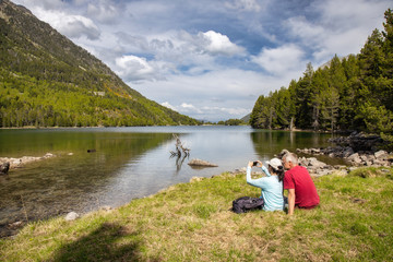 Fototapeta na wymiar Beautiful Pyrenees mountain landscape, nice lake with tourist couple from Spain, Catalonia.