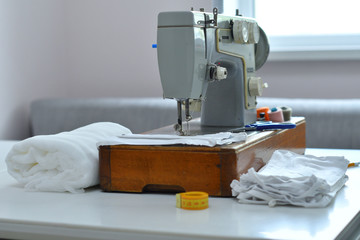 Homemade medical mask in the process. Sewing virus face mask at home. Detail on sewing machine.