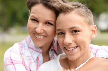 Fototapeta premium Close up portrait of beautiful mother with son in park