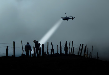 Silhouette of immigrants in the other side of barbed wire and helicopter flash them in the air... - obrazy, fototapety, plakaty