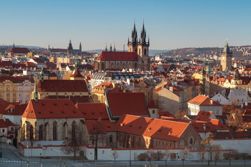 Fototapeta na wymiar Overall view of Old Town of Prague shortly after sunrise, sunny spring day with blue sky. St Agnes convent in foreground, rooftop and towers of Church of Our Lady before Tyn in middle.