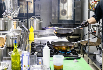 Fototapeta na wymiar Chef in the kitchen at the restaurant prepares dishes