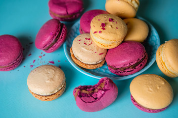 Fototapeta na wymiar Macaroons on blue background, a lot of colorful french cookies macarons.