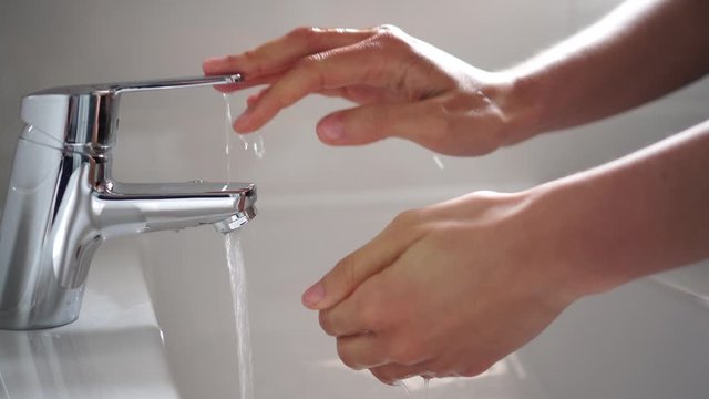 Persona lavando las manos para desinfectar y prevenir la infecci&oacute;n de corona virus con agua y jab&oacute;n en el ba&ntilde;o c&aacute;mara lenta HD