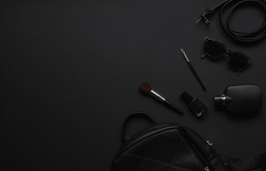 Accessories for women's beauty. Black monochromatic composition on black background.Minimalist...
