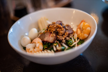 Vietnamese food dish with noodle, shrimp, quail egg, pork and vegetables