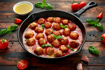 Lean Turkey breast meat balls in cheesy tomato passata sauce served in cast iron frying pan skillet