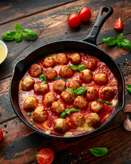 Lean Turkey breast meat balls in cheesy tomato passata sauce served in cast iron frying pan skillet