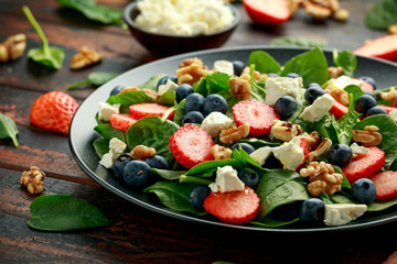 Spinach, Strawberry, blueberry salad with walnut and feta cheese. Summer healthy food