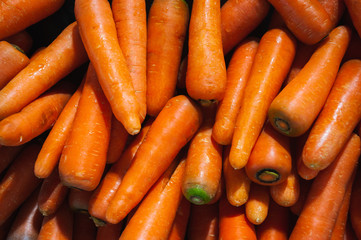 Plenty of fresh orange carrot on a counter in a market