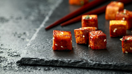 Fried Tofu with chopstick and sesame seeds on rustic stone board - obrazy, fototapety, plakaty