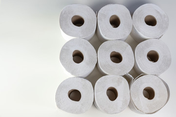 Nine toilet paper rolls from above, lack after shoppers panic buying due to coronavirus outbreak, gray background with copy space