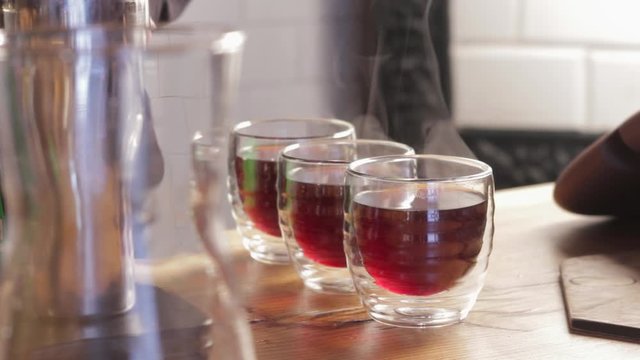 Steaming cups of coffee or tea on a table close up.
