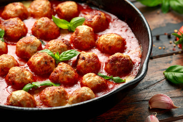 Lean Turkey breast meat balls in cheesy tomato passata sauce served in cast iron frying pan skillet