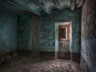 Fototapeta na wymiar Habitación azul con ventana en la penumbra de casa abandonada.