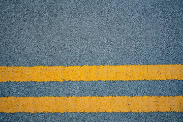 road marking - two yellow stripes on gray asphalt fragment