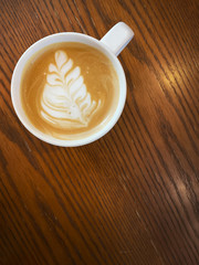  top view of Hot art Latte Coffee in a cup on wooden table.