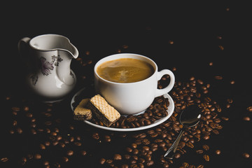 cup of coffee with beans on black background