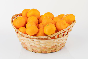 wicker basket with some tangerines isolated on white background