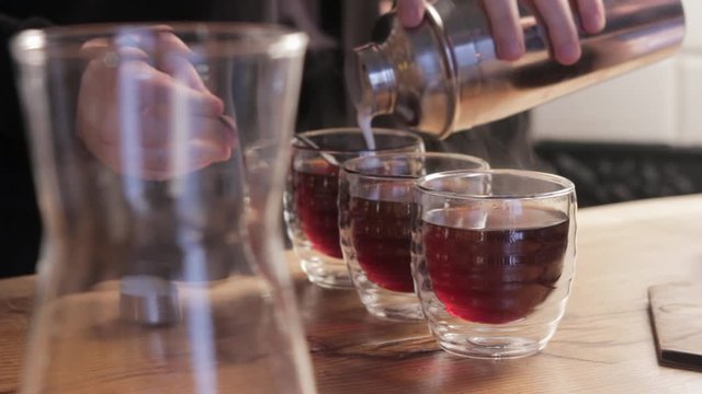 Barista making irish coffee. Pouring whipped cream into cups of coffee.