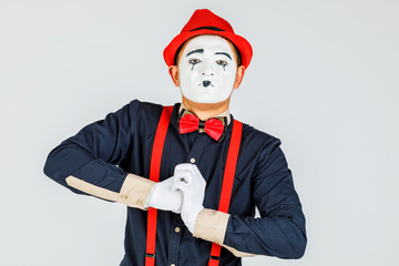 Clown with red suspenders and red hat on white background