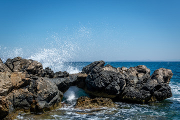 wave clatters against rocks in the sea coast Greece Kos