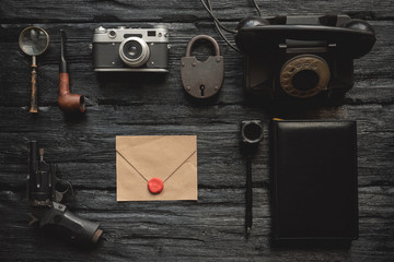 Top secret letter in envelope on flat lay detective agent desk background.