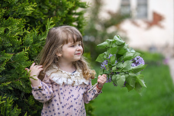 little girl with a bouquet of wild flowers.  girl with flowers. portrait of a girl in garden