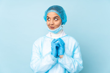 Young surgeon Indian woman in blue uniform scheming something
