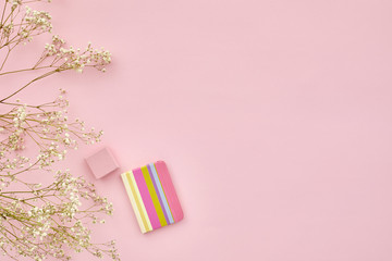 flat lay gypsophila flowers and a diary on pink background, top view. empty space for text.