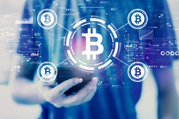 Bitcoin theme with young man using a smartphone