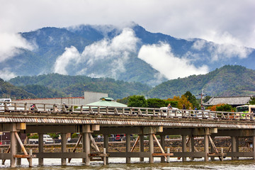 Old style wooden bridge with mountains in the background
