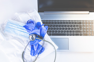 Home Office Medizin - Laptop mit Mundschutz, Stethoskop, Schutz gegen Virus, Infektion, Handy und...