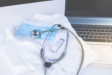 Home Office Medizin - Laptop mit Mundschutz, Stethoskop, Schutz gegen Virus, Infektion, Handy und...